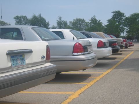 2001 Ford Crown Victoria - Several Ford Crown Victorias are parked in a lot, viewed from the rear.