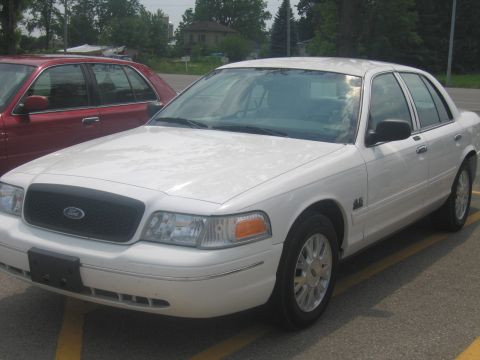 2001 Ford Crown Victoria - Front 3/4 view of a white 2001 Ford Crown Victoria sedan parked outdoors.