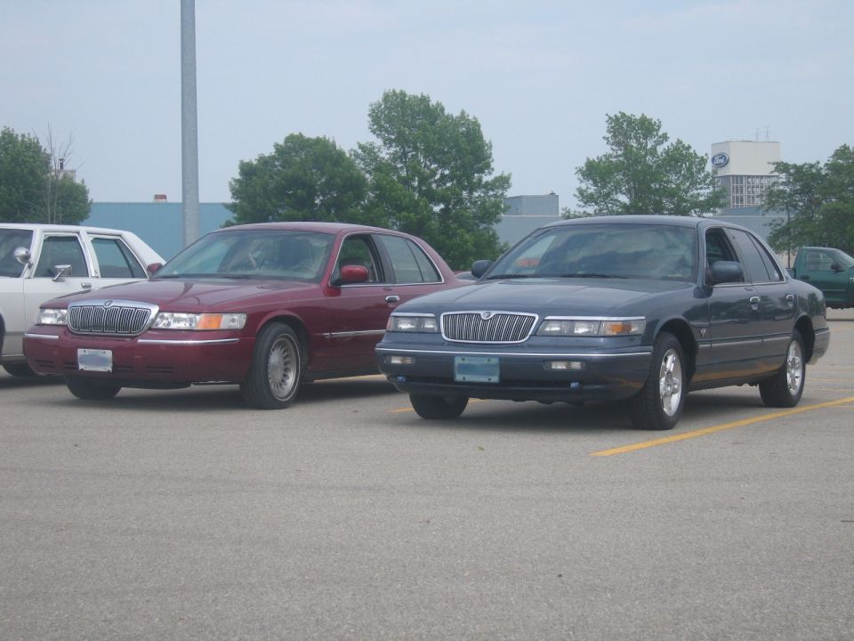 Dark blue sedan parked next to a maroon sedan in a parking lot