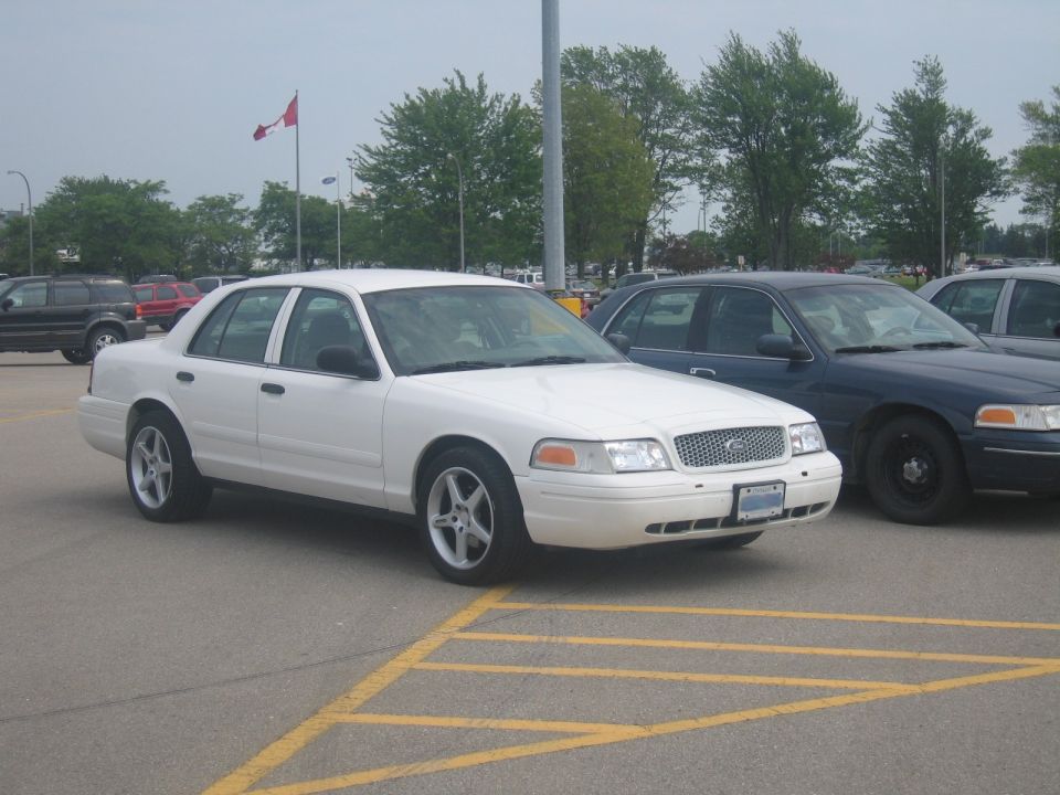 White 2001 Ford Crown Victoria parked in a lot, front 3/4 view, clean condition