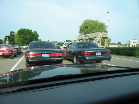 2001 Ford Crown Victoria - Rear view of a dark sedan, possibly a 2001 Ford Crown Victoria, in traffic.