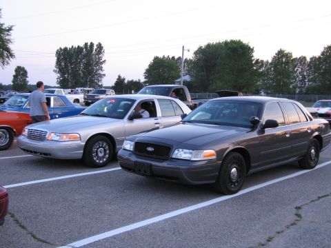 2001 Ford Crown Victoria - Photo of two Ford Crown Victoria sedans parked side by side in a lot at dusk.