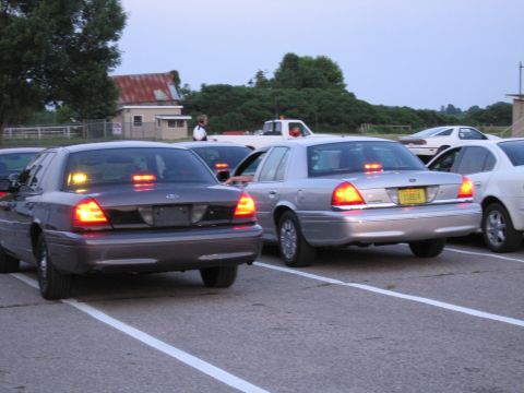 2001 Ford Crown Victoria - Photograph of Ford Crown Victoria sedans in a parking area at a dragstrip, not a technical document.