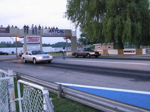 2001 Ford Crown Victoria - Photograph of sedans at the dragstrip starting line, not a technical document.