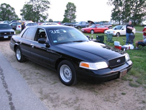2001 Ford Crown Victoria - Photograph of a black Ford Crown Victoria at a car gathering, not a technical document.