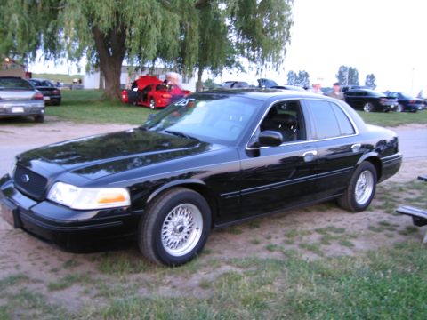 2001 Ford Crown Victoria - Photograph of a black Ford Crown Victoria at an outdoor event, not a technical document.