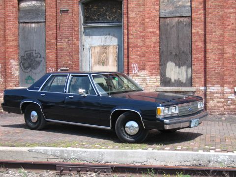 2001 Ford Crown Victoria - Photograph of a Ford LTD Crown Victoria by a brick building, not a technical document.
