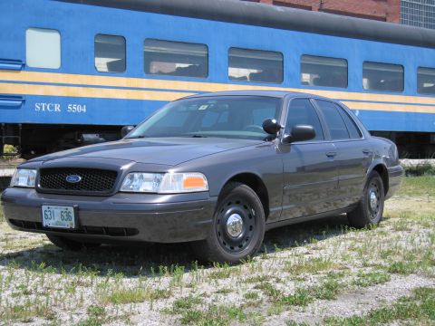 2001 Ford Crown Victoria - Front-quarter photo of a gray Ford Crown Victoria sedan in front of a blue STCR 5504 passenger train car.