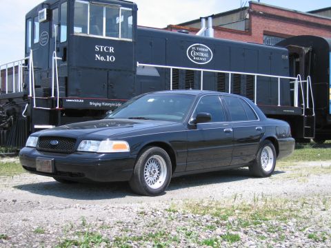 2001 Ford Crown Victoria - Photo of a black Ford Crown Victoria sedan posed in front of a black St. Thomas Central Railway locomotive.