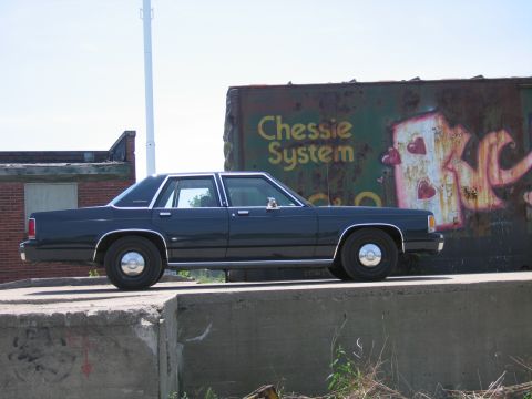 2001 Ford Crown Victoria - Photograph of a black Ford LTD Crown Victoria parked in front of a Chessie System railroad boxcar.