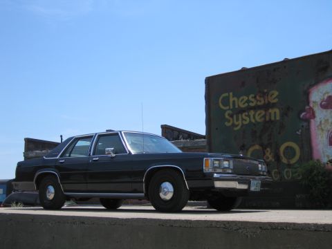 2001 Ford Crown Victoria - Photograph of a black Ford LTD Crown Victoria parked next to a Chessie System railroad boxcar.