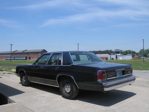 2001 Ford Crown Victoria - Photograph of a black Ford LTD Crown Victoria sedan parked in an open railyard.