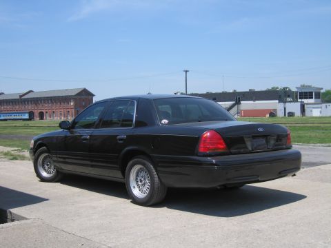 2001 Ford Crown Victoria - Photo of a black Ford Crown Victoria sedan in a lot, not a technical document.