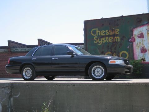 2001 Ford Crown Victoria - Photo of a black Ford Crown Victoria by a Chessie System boxcar, not a technical document.