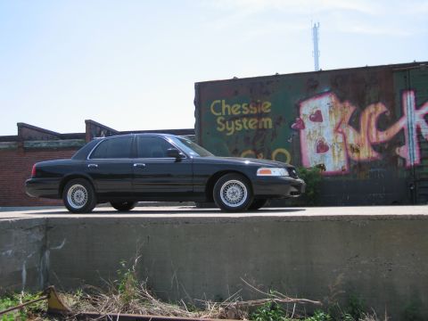 2001 Ford Crown Victoria - Photo of a black Ford Crown Victoria by a Chessie System boxcar, not a technical document.