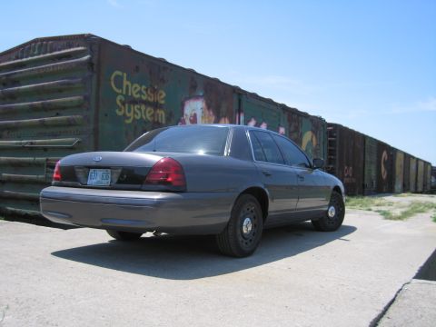 2001 Ford Crown Victoria - Photo of a gray Ford Crown Victoria by a Chessie System boxcar, not a technical document.