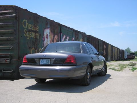 2001 Ford Crown Victoria - Photo of a gray Ford Crown Victoria by Chessie System boxcars, not a technical document.
