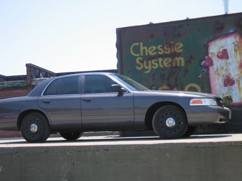 2001 Ford Crown Victoria - Photo of a gray Ford Crown Victoria by a Chessie System boxcar, not a technical document.