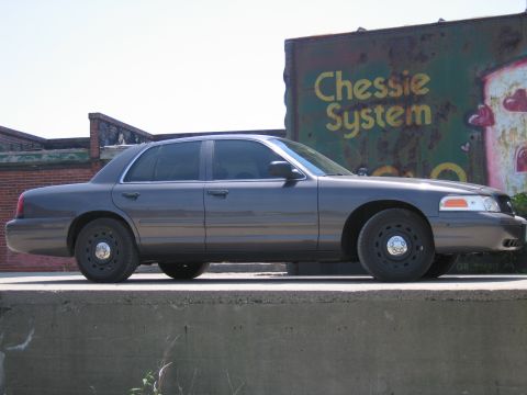 2001 Ford Crown Victoria - Photo of a gray Ford Crown Victoria by a Chessie System boxcar, not a technical document.