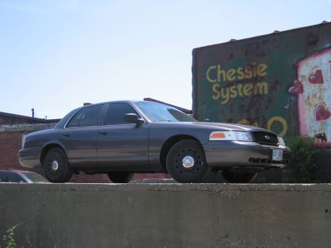 2001 Ford Crown Victoria - Photo of a gray Ford Crown Victoria near a Chessie System boxcar, not a technical document.