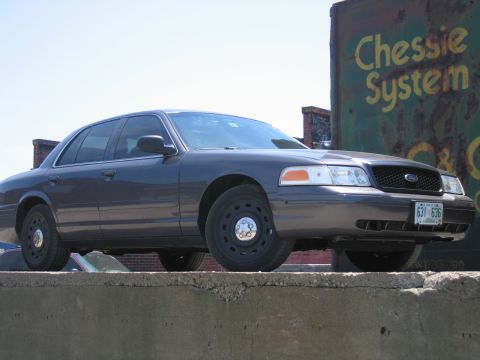 2001 Ford Crown Victoria - A dark 2001 Ford Crown Victoria is seen from the front three-quarter angle.