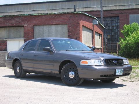 2001 Ford Crown Victoria - This 2001 Ford Crown Victoria sedan is seen from the front quarter angle in front of a brick building.
