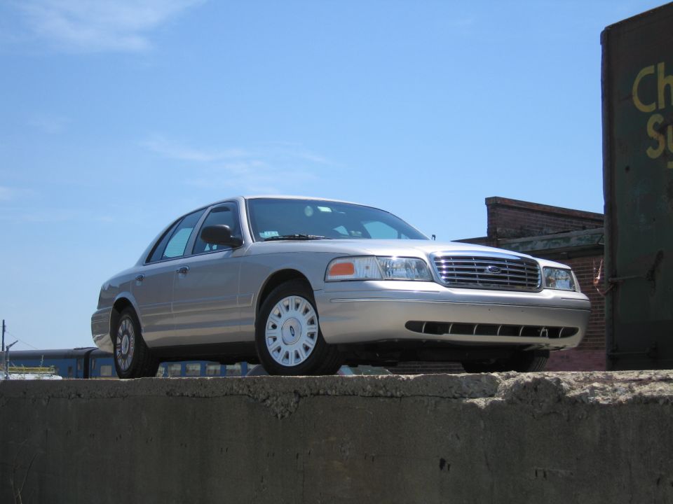 Silver 2001 Ford Crown Victoria parked on a concrete ledge