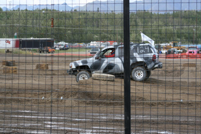 Camouflaged SUV with number 124 on side, seen from 3/4 front