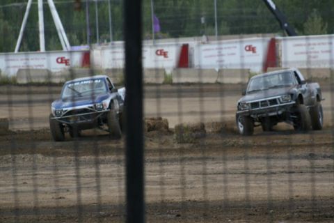 1975 Toyota Land Cruiser - Two pickup trucks compete on a dirt track, with one appearing to be from the late 1980s.