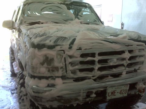 1996 Ford Bronco - Front view of a 1996 Ford Bronco being washed, suds covering the grille and hood.
