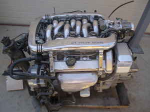 1993 Ford Taurus - Small photo of a bare V6 engine sitting on the ground, topped with a polished Yamaha-style tuned intake manifold with long curved runners a…