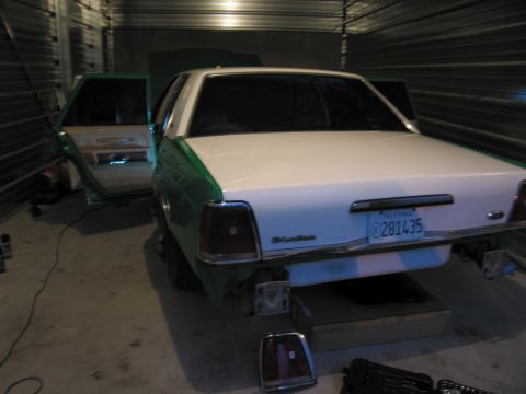 1991 Ford LTD Crown Victoria - The rear of a two-tone Ford Crown Victoria is visible with its doors open inside a garage.