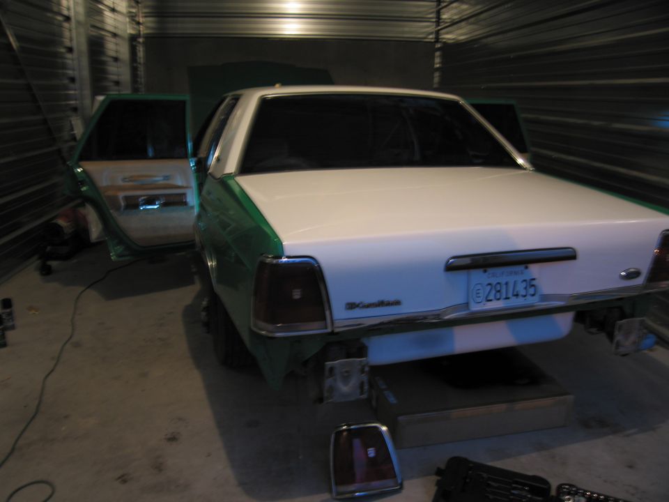 White and green Ford Crown Victoria with doors open, rear view, license plate 0281435