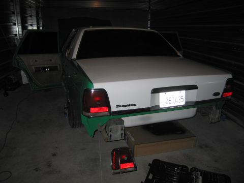 1991 Ford LTD Crown Victoria - Rear view of a 1991 Ford Crown Victoria LTD, showing its white and green exterior with doors ajar and license plate 281435.