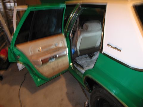 1991 Ford LTD Crown Victoria - The interior of a green and white sedan is shown with the front and rear doors open, revealing the seats and door panels.