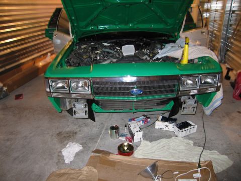 1991 Ford LTD Crown Victoria - Front view of a green 1980s Ford Crown Victoria with its hood open, parked indoors with tools nearby.