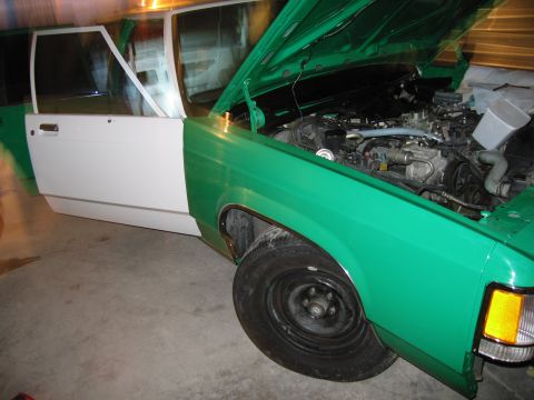 1991 Ford LTD Crown Victoria - This vehicle is undergoing a two-tone paint job, with the front fenders and hood painted green, and the doors painted white.