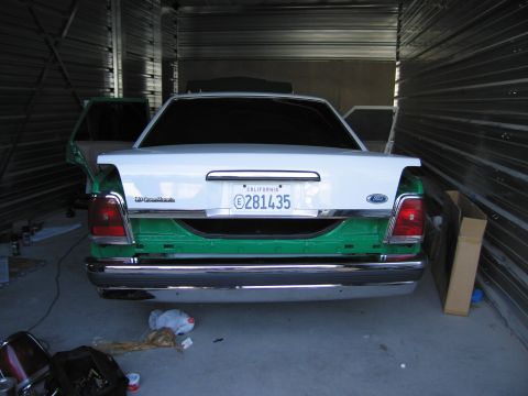 1991 Ford LTD Crown Victoria - The rear of a 1991 Ford Crown Victoria LTD is shown, with its trunk open and the lower body painted green.