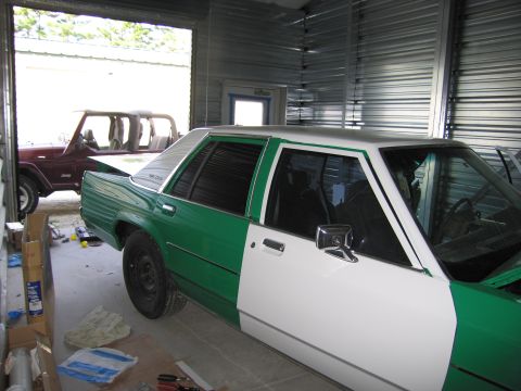 1991 Ford LTD Crown Victoria - A two-tone green and white 1991 Ford Crown Victoria LTD sedan is parked inside a garage next to a Jeep.