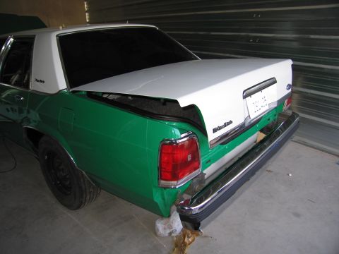 1991 Ford LTD Crown Victoria - The rear of a two-tone Ford Crown Victoria, green on the lower half and white on the top, is shown with its trunk open.