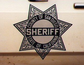 1991 Ford LTD Crown Victoria - Close-up of a San Diego County Sheriff badge, indicating law enforcement presence.