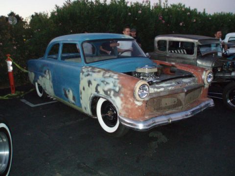 1953 Ford Mainline - A 1953 Ford Mainline hot rod with primer and blue paint is parked next to other vehicles.