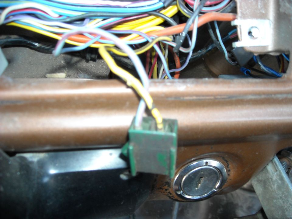 1978 Ford Bronco interior showing a complex wiring harness connected to a green connector and a chrome ignition cylinder