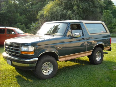 1994 Ford Bronco - Green 1994 Ford Bronco with tan trim parked outdoors.