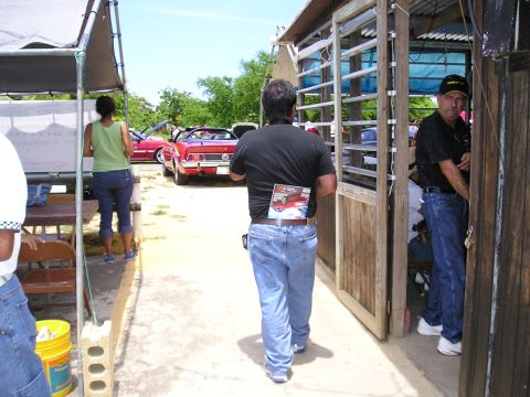 2009 Ford Mustang - A red convertible is parked outdoors, with people milling around.