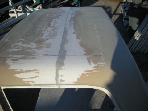 1991 Ford Bronco - The roof of a car is covered in primer and body filler, indicating repair work.