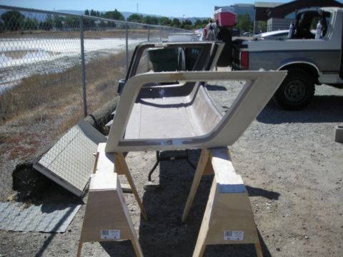 1991 Ford Bronco - A car door frame is disassembled and placed on sawhorses outdoors, with a truck visible behind it.
