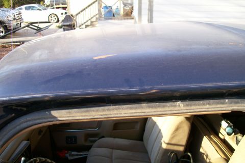 1988 Ford Bronco - The photo shows the interior and roof of a dark blue SUV, with other vehicles in the background.