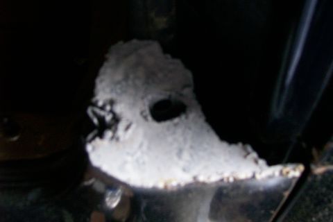 1988 Ford Bronco - Close-up of a corroded metal bracket, likely part of a vehicle's undercarriage.