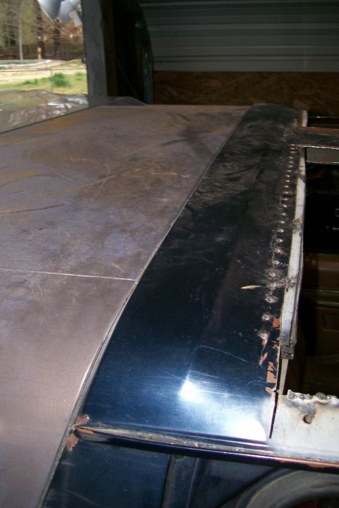 1988 Ford Bronco - Close-up view of a vehicle's roof panel undergoing modification, with visible seams and rivets.